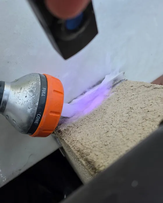 Révélation d'un traceur fluorescent violet à la lampe UV sur l'acrotère d'une toiture-terrasse, intervention de GBL Détection.