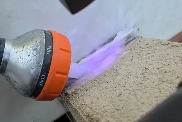 Révélation d'un traceur fluorescent violet à la lampe UV sur l'acrotère d'une toiture-terrasse, intervention de GBL Détection.
