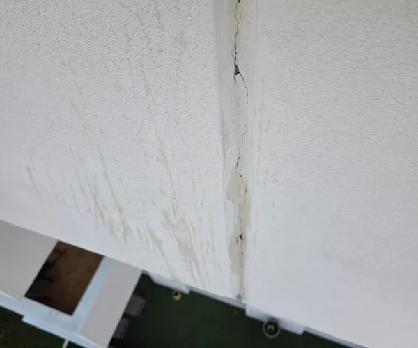 Fissure de façade avec traces d'infiltration d'eau