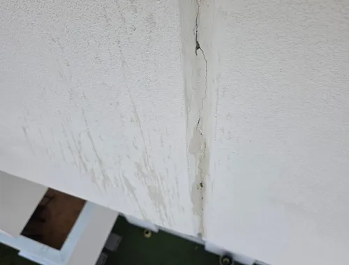 Fissure de façade avec traces d'infiltration d'eau