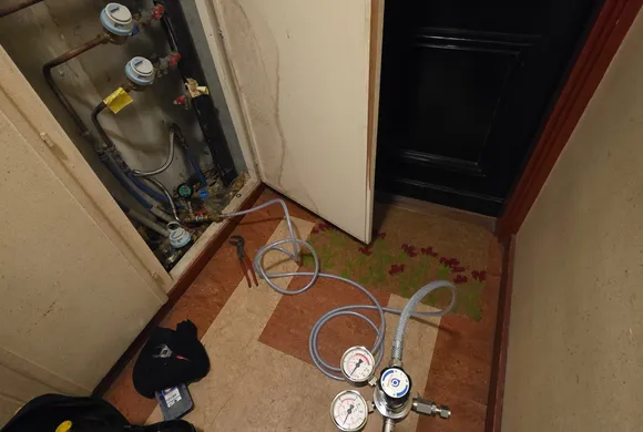 Matériel de détection de fuite (manomètres et bonbonne de gaz traceur) déployé dans un couloir d'immeuble par GBL Détection.
