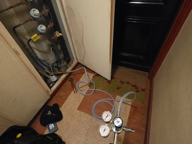 Matériel de détection de fuite (manomètres et bonbonne de gaz traceur) déployé dans un couloir d'immeuble par GBL Détection.