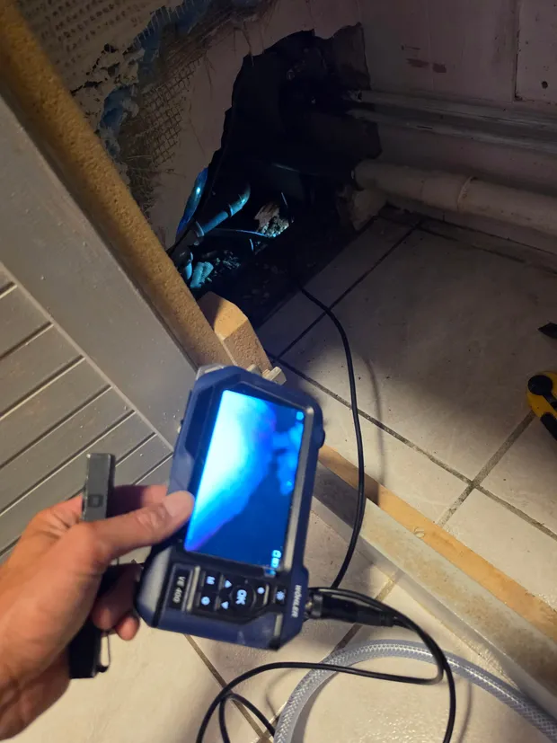 Caméra d'inspection endoscopique utilisée pour visualiser des canalisations à l'intérieur d'une cloison ouverte.