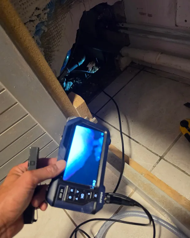 Caméra d'inspection endoscopique utilisée pour visualiser des canalisations à l'intérieur d'une cloison ouverte.