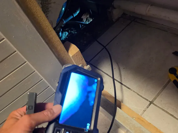 Caméra d'inspection endoscopique utilisée pour visualiser des canalisations à l'intérieur d'une cloison ouverte.