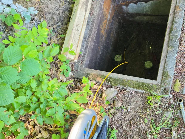 Câble d'aiguille de traçage introduit dans un regard de visite extérieur pour tracer un réseau enterré, technique utilisée par GBL Détection.